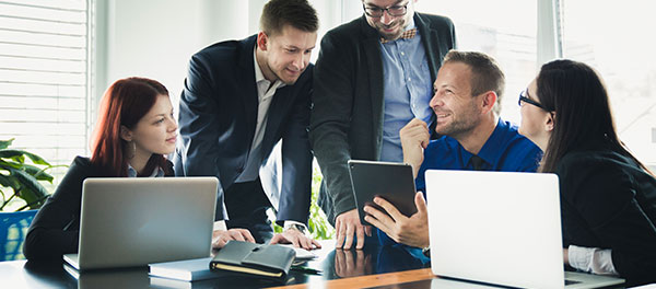 Happy consulting executives looking at laptops.jpg