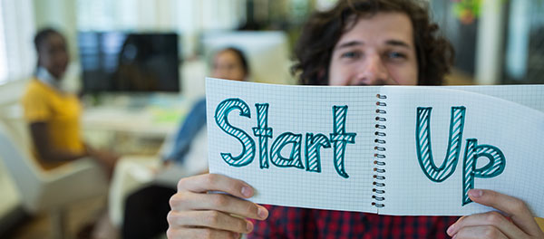 Portrait of male business executive holding start up sign